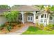 Inviting home exterior showcasing a brick walkway, colorful landscaping, and double door entryway at 950 Trotter St, Nokomis, FL 34275