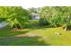Expansive front yard featuring lush landscaping, mature trees, and a circular driveway leading to the home at 950 Trotter St, Nokomis, FL 34275