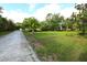 Expansive lot with mature trees and landscaping, with bench seating, offering a serene and private setting at 950 Trotter St, Nokomis, FL 34275