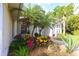 Landscaped front yard with palm trees and a variety of colorful plants at 950 Trotter St, Nokomis, FL 34275