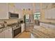 Modern kitchen with stainless steel appliances and granite countertops at 950 Trotter St, Nokomis, FL 34275