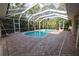 Inviting pool inside a screen enclosure, offering a blend of relaxation and privacy with tropical foliage at 950 Trotter St, Nokomis, FL 34275
