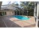 The in-ground pool has a screen enclosure, brick pavers, spa and mature landscaping at 950 Trotter St, Nokomis, FL 34275