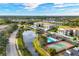 Aerial view of community featuring a pool, tennis court, pond, and green spaces at 9630 Club South Cir # 6303, Sarasota, FL 34238