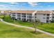 Exterior shot of a multi-story condo building surrounded by green lawns and a paved walkway at 9630 Club South Cir # 6303, Sarasota, FL 34238
