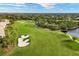 Aerial view of the golf course, highlighting its extensive green space, sand traps and picturesque lake at 9630 Club South Cir # 6303, Sarasota, FL 34238