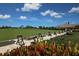 Golf course with lush green grass and practice teeing areas with clear skies in the background at 9630 Club South Cir # 6303, Sarasota, FL 34238