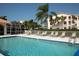 Community pool with clear blue water, surrounded by lounge chairs and tropical landscaping at 9630 Club South Cir # 6303, Sarasota, FL 34238