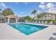 Community swimming pool with covered lanai, tables, chairs, and sun loungers, perfect for relaxation at 9630 Club South Cir # 6303, Sarasota, FL 34238