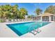 Inviting community pool area with mature trees, a cabana, and ample lounging space, ideal for leisure at 9630 Club South Cir # 6303, Sarasota, FL 34238