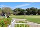 Golfers enjoy a sunny day at the community's putting green, framed by bright red flowers at 9630 Club South Cir # 6303, Sarasota, FL 34238