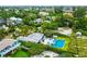 This aerial view reveals a charming neighborhood surrounded by mature trees, featuring a private pool and beach access at 102 77Th St, Holmes Beach, FL 34217