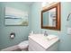 Bathroom with a white sink, toilet, and beach-themed artwork at 102 77Th St, Holmes Beach, FL 34217