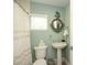 Bathroom featuring a toilet, sink, and decorative mirror at 102 77Th St, Holmes Beach, FL 34217