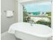 Close up of luxurious bathroom with a claw foot tub overlooking the pool area at 102 77Th St, Holmes Beach, FL 34217