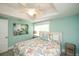 A bright bedroom featuring a queen bed with coral-themed bedding and a ceiling fan at 102 77Th St, Holmes Beach, FL 34217