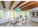 Dining room with wood beams, decorative chandelier, and bright natural light at 102 77Th St, Holmes Beach, FL 34217