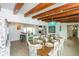 Dining room with wood beams, decorative chandelier, and views into the living room at 102 77Th St, Holmes Beach, FL 34217