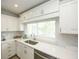 Bright kitchen features white cabinets, white countertops, stainless steel sink, and a window at 102 77Th St, Holmes Beach, FL 34217