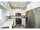 Modern kitchen with white cabinets, stainless steel appliances, and white countertops at 102 77Th St, Holmes Beach, FL 34217