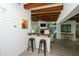 Partial view of the open concept living room showing wood beams, a TV, and a bar at 102 77Th St, Holmes Beach, FL 34217