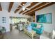 Open-concept living room flowing to the dining room featuring coastal decor and wood beam ceilings at 102 77Th St, Holmes Beach, FL 34217