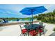 Outdoor patio with dining set under a large umbrella overlooking a serene backyard pool at 102 77Th St, Holmes Beach, FL 34217