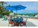 Charming outdoor patio with dining set under a large umbrella, perfect for seaside meals and entertaining at 102 77Th St, Holmes Beach, FL 34217