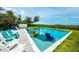 Inviting pool with in-water seating, umbrella, and beautiful outdoor lounge area for relaxing and entertaining at 102 77Th St, Holmes Beach, FL 34217