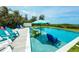 Relaxing pool area with in-pool seating and colorful Adirondack chairs, perfect for enjoying the sun at 102 77Th St, Holmes Beach, FL 34217