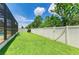Backyard with green grass, a screened lanai, and a white vinyl privacy fence at 11254 82Nd St E, Parrish, FL 34219