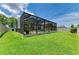 Spacious backyard with green grass, a screened lanai, and a white vinyl fence at 11254 82Nd St E, Parrish, FL 34219