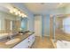 Bathroom showcases double sinks, a large mirror, and a separate glass shower and tub at 11254 82Nd St E, Parrish, FL 34219
