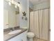 Bathroom featuring a granite countertop sink, decorative flowers on the wall, and a shower with patterned curtain at 11254 82Nd St E, Parrish, FL 34219