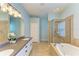 Bright bathroom featuring double sinks, a large mirror, and separate glass shower and tub at 11254 82Nd St E, Parrish, FL 34219