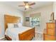 Bright bedroom with a wooden bed frame, a window, and a dresser, creating a cozy space at 11254 82Nd St E, Parrish, FL 34219