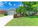 Well-maintained single-story house featuring a lush green lawn with vibrant tropical landscaping and a two car garage at 11254 82Nd St E, Parrish, FL 34219