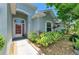 Inviting front entrance with a red-trimmed door, surrounded by colorful landscaping and a paver walkway at 11254 82Nd St E, Parrish, FL 34219