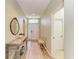 Light-filled hallway showcasing a console table, decorative mirror, and a view of the front door at 11254 82Nd St E, Parrish, FL 34219