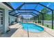 Backyard swimming pool with a screened enclosure, brick patio, and surrounding greenery at 11254 82Nd St E, Parrish, FL 34219