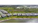 Aerial view of waterfront homes featuring pools and screened lanais overlooking the lake at 1182 Blue Shell Loop, Sarasota, FL 34240