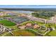 Aerial view of new community amenities featuring tennis courts, playgrounds, trails, and landscaping near a lake at 1182 Blue Shell Loop, Sarasota, FL 34240
