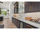 Wet bar with dark cabinets, gold hardware, marble countertop, and glass shelving at 1182 Blue Shell Loop, Sarasota, FL 34240