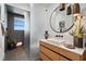 Modern bathroom featuring wood vanity, vessel sink, round mirror, and glass-enclosed shower at 1182 Blue Shell Loop, Sarasota, FL 34240