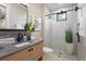 Stylish bathroom with wood vanity, black fixtures, and a glass-enclosed shower at 1182 Blue Shell Loop, Sarasota, FL 34240
