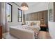 Bright bedroom showcasing a decorative headboard, unique lighting, and a large window at 1182 Blue Shell Loop, Sarasota, FL 34240