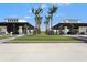 A relaxing outdoor community space between covered buildings with grass and palm trees at 1182 Blue Shell Loop, Sarasota, FL 34240