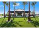 Community clubhouse featuring open-air design and a vibrant green lawn with palm trees at 1182 Blue Shell Loop, Sarasota, FL 34240