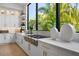Bright, modern kitchen featuring stainless steel appliances, natural lighting, white counters, and plenty of cabinet space at 1182 Blue Shell Loop, Sarasota, FL 34240