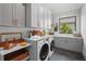Well-organized laundry room with sleek cabinetry, modern appliances, and a bright window offering natural light at 1182 Blue Shell Loop, Sarasota, FL 34240